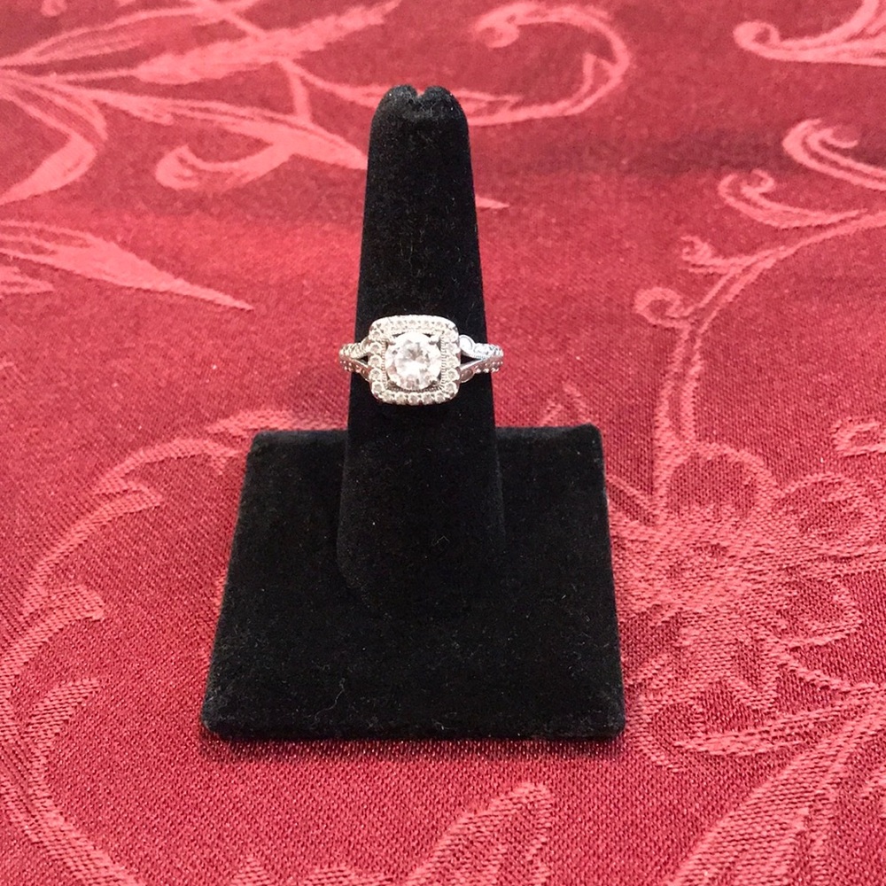 Silver simulated diamond ring in vintage setting with solitare in center .